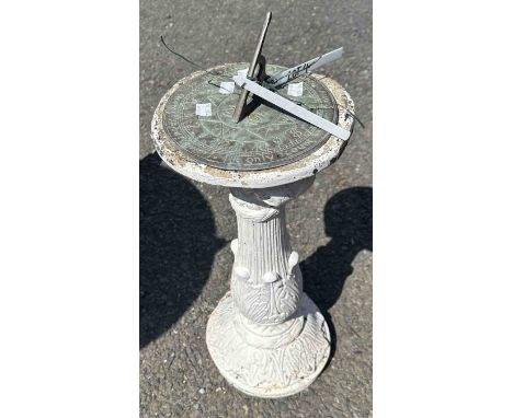 A white painted concrete pedestal with brass sundial