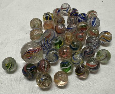 A small quantity of antique hand blown glass enamel twist marbles