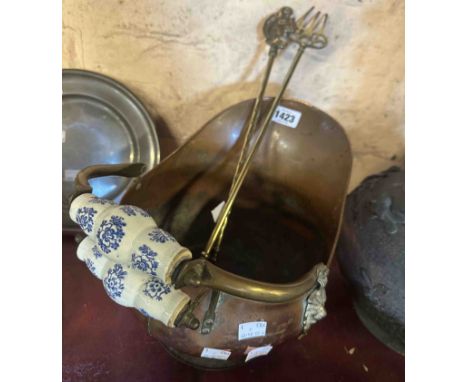 A vintage copper coal scuttle of helmet form with blue printed ceramic handles containing two old toasting forks