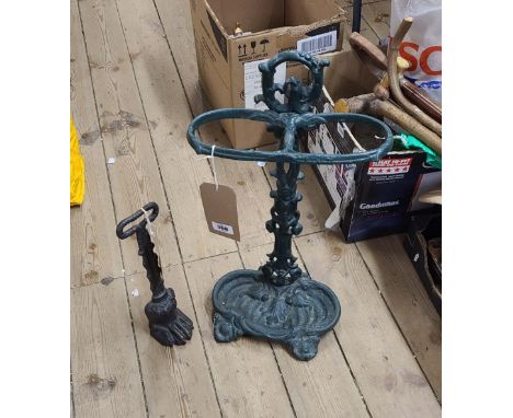 An antique style cast iron stick stand with integral drip tray - sold with a cast iron doorstop of lion paw form