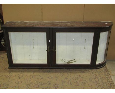 A vintage stained pine wall mounted shop display cabinet with curved end, enclosed by a pair of glazed panelled doors with br