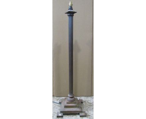 A brass column lamp standard with reeded stem, raised on a square cut stepped base 