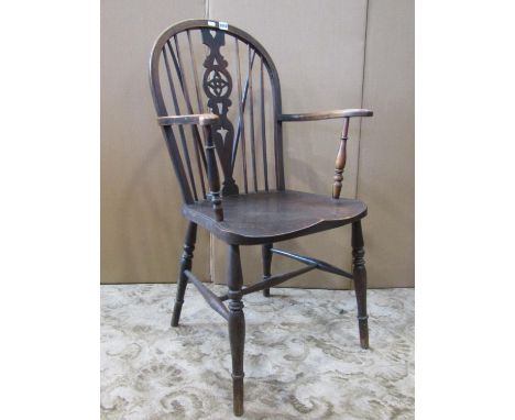 A Windsor elbow chair with shaped and pierced splat, stick back, scrolled arms and turned supports principally in elm and bee