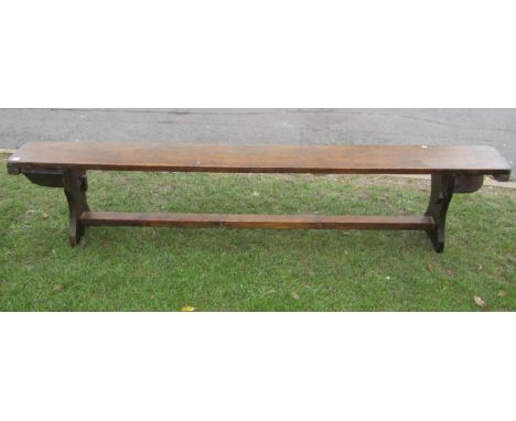 A 19th century bench of simple construction raised on waisted end supports, 245 cm in length 