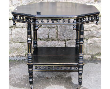 An Edwardian ebonised centre table, the octagonal top raised on four turned supports united by a square cut under gallery wit