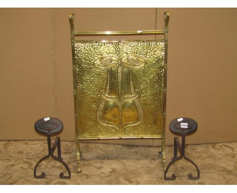 An Art Nouveau embossed brass firescreen with geometric detail, together with a pair of Art Nouveau iron work fire dogs 