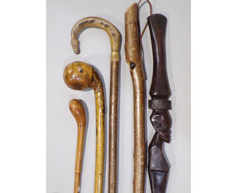 Mixed collection of walking sticks, four rustic examples, a carved tribal hardwood stick and a knob kerry (6) 