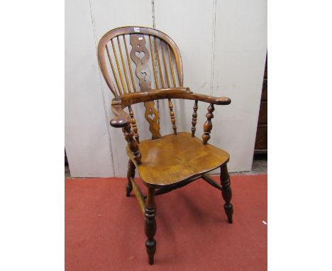 A Georgian comb back elbow chair principally in birch and yew wood with shaped and pierced splat and turned mouldings 