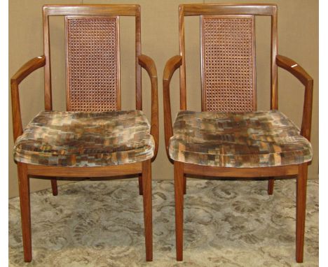 A pair of vintage teak wood G plan elbow chairs each with cane panelled backs together with a further vintage ottoman with wh