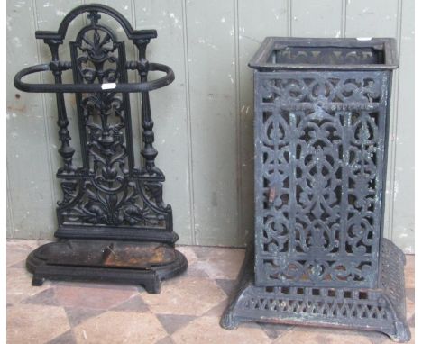 A small reproduction cast iron umbrella/stick stand with decorative pierced and scrolling back over a removable drip tray, 33