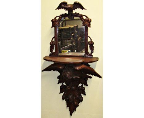 19th century carved mahogany wall bracket, the shaped shelf supported by an eagle with outstretched wings over trailing fruit