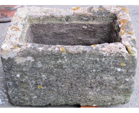 A weathered natural stone trough of rectangular form with drainage hole x 57cm long x 43cm wide x 30cm deep (crack to top cor