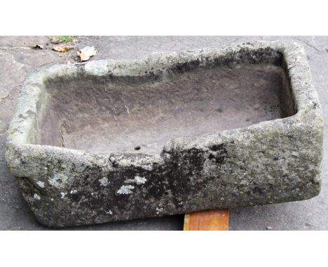 A shallow weathered natural stone trough of rectangular form with two drilled drainage holes, 59cm long x 38cm wide x 18cm de