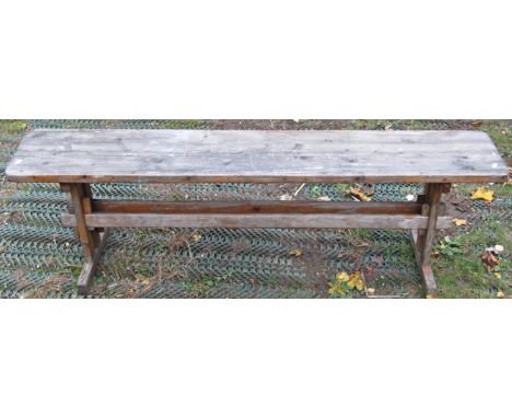 A two seat garden bench with weathered timber lathes, raised on cast iron/allow supports, together with a weathered pine seat