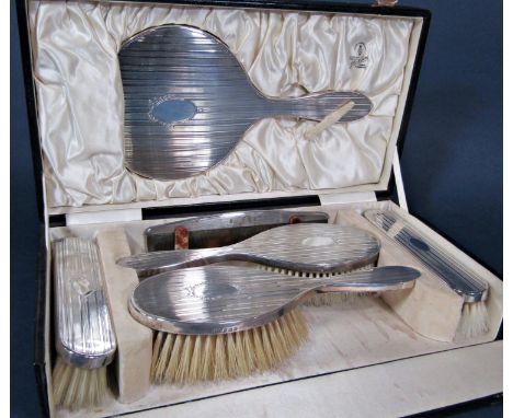 Cased 1920s silver six piece dressing set comprising four brushes, hand mirror and silver topped comb, within a display case 