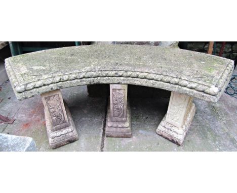 A reclaimed four sectional garden bench, with curved slab seat, raised on column supports with foliate relief detail, 124cm l