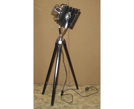 A vintage style lantern in the form of a bellows camera on a tripod base with black and chrome finish 