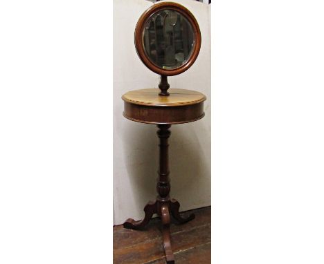 A Victorian mahogany shaving stand, the circular mirror with bevelled edge plate, raised on adjustable brass column, the encl