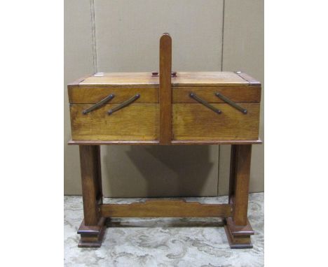 An oak ladies sewing cabinet with telescopic action raised on a stretcher base, together with a Georgian oak snap top table, 