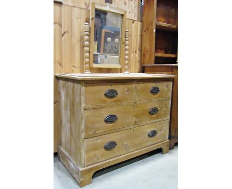An Edwardian waxed pine dressing chest fitted with two long and two short drawers, the swing mirror raised on bobbin supports