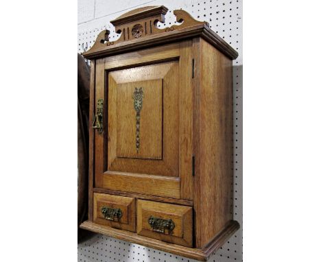 Aesthetic period oak hanging wall cupboard, with raised architectural swan neck pediment over a single panelled door with She