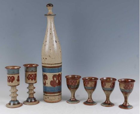 A New Zealand studio pottery salt-glazed wine set, comprising long-necked decanter and stopper, h.51cm, a pair of pedestal ch