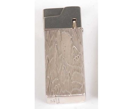 A circa *1950s* Tiffany & Co sterling silver pocket cigarette lighter, having stylised engine turned decoration, with hinged 