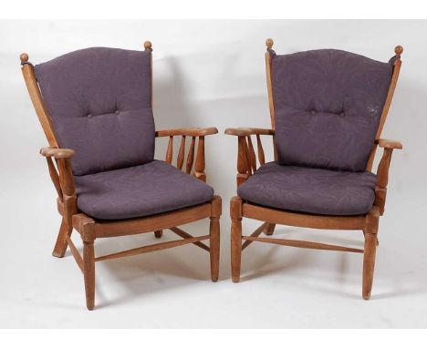A pair of mid-20th century oak framed ladderback armchairs, the shaped arm rests on spindle turned supports, to further turne