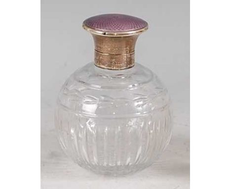 An Art Deco silver and purple guilloche enamelled cut crystal glass bodied perfume bottle, the hinged dome cover with inset s