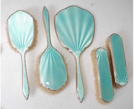An Art Deco silver and green guilloche enamel decorated five-piece dressing table set, comprising hand mirror with bevelled o