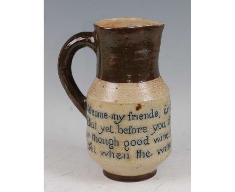 A Martin Brothers stoneware single handled wine pitcher, the body inscribed 'Welcome my friende, Drink with a noble hearte, B