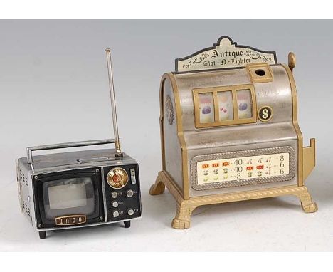 A Japanese novelty table lighter in the form of an antique slot machine by Waco, lacking striker, h.17cm, w.15cm; together wi