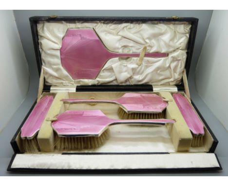 An Art Deco silver and pink enamel dressing table set, cased, Birmingham 1936, W.G. Sothers Ltd., (no comb) 