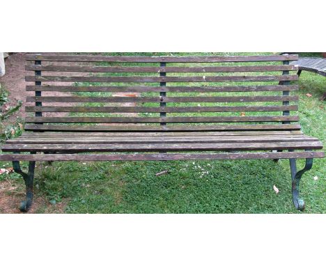 A vintage garden bench with weathered timber slatted seat and combined back raised on sprung steel supports, 183 cm (6ft long