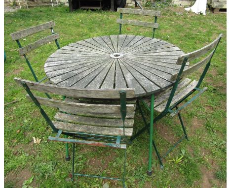 A weathered circular garden table with hardwood sunburst patterned top raised on green painted tubular steel supports, 94 cm 