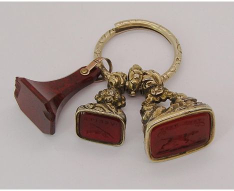 Yellow metal fob with three attached seals comprising two intaglio-cut carnelian examples reading 'Take Heed' and 'Verite' an