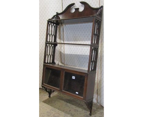 A Chippendale revival mahogany flight of hanging wall shelves with architectural broken swan neck pediment flanked by pierced
