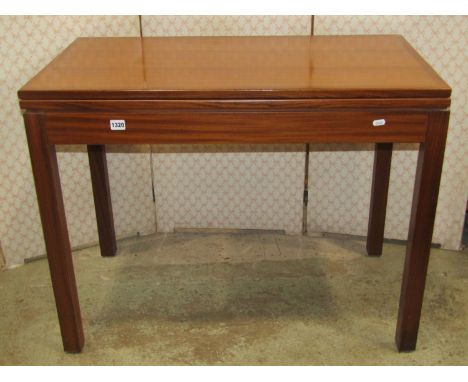 A teak foldover top card table of rectangular form raised on square cut supports 91 cm wide 