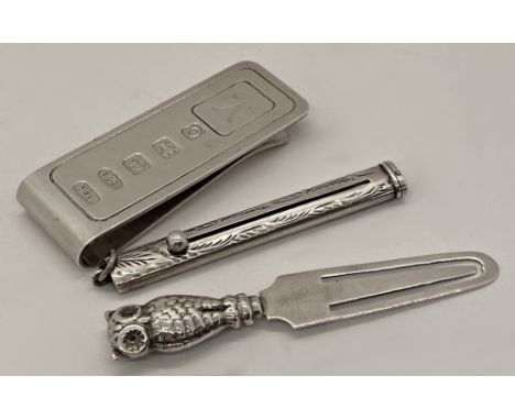 A Victorian silver retractable tooth pick by Villiers &amp; Jackson, a silver page marker with an owl, and a silver money cli