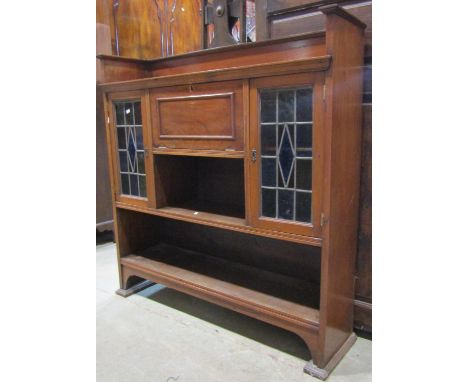 An Edwardian Arts &amp; Crafts style walnut freestanding bureau bookcase combination, the central fall front enclosing a simp