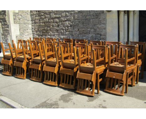 Set of eleven oak chapel chairs with stick backs, prayer book holders and solid seats, all individually stamped 'Glenister ma