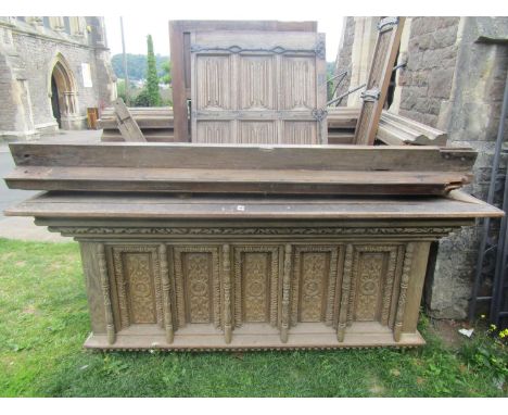 An antique carved oak vestibule fitted with three doors all with linenfold detail and steel hinges and set beneath a massive 