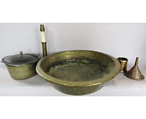 A collection of metal ware, including a brass basin, a copper funnel, a converted brass candlestick, a brass cooking vessel a