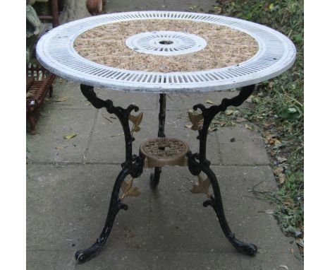 A painted cast aluminium garden terrace table with decorative circular pierced top raised on swept and scrolled supports 