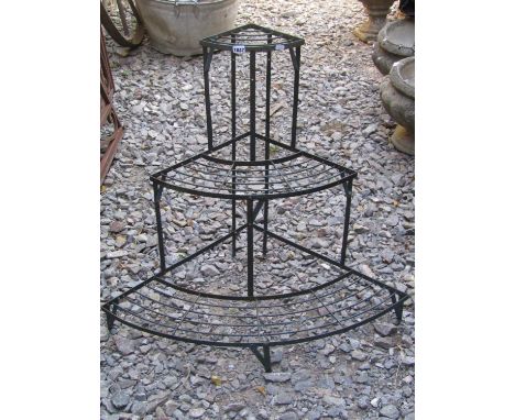 A weathered green painted light steel framed freestanding three tier graduated and bow fronted plant stand 84 cm wide x 75 cm