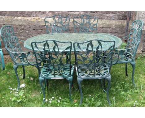 A contemporary green painted cast aluminium garden terrace table of oval form with decorative pierced top together with six (