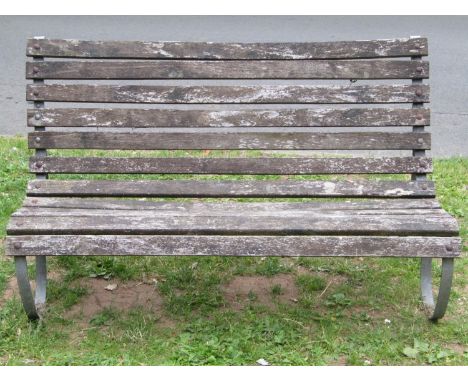A vintage garden bench with weathered timber lathes raised on galvanized sprung steel supports 148cm wide 