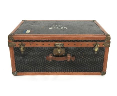 A late 19th century Malles Goyard canvas, tan leather, metal and studded travelling trunk, having end carry handles, the hing