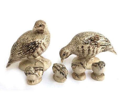 A group of ceramic sculptures of a two adult partridges and four chicks 