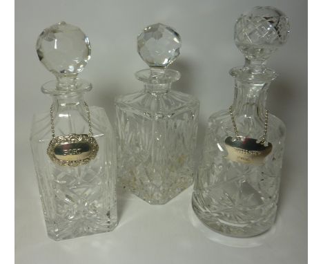 Three cut crystal decanters, together with hallmarked silver 'Port' and 'Whisky' labels Condition Report Click here for furth